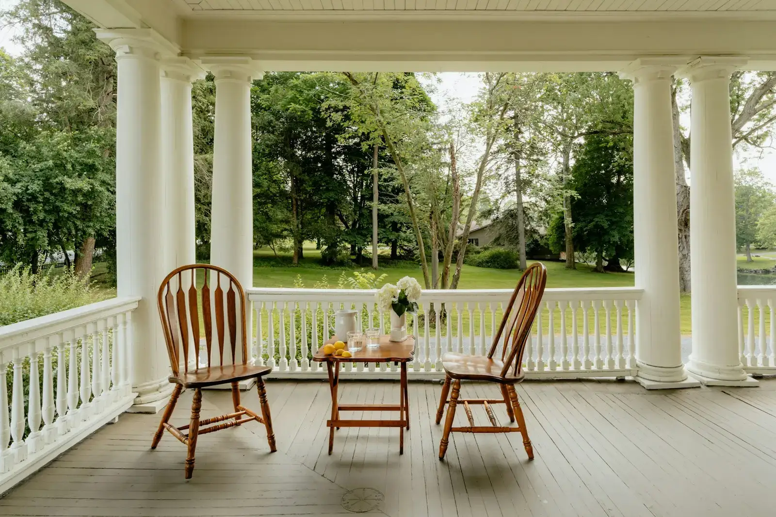 Two chairs and a small table on a front porch