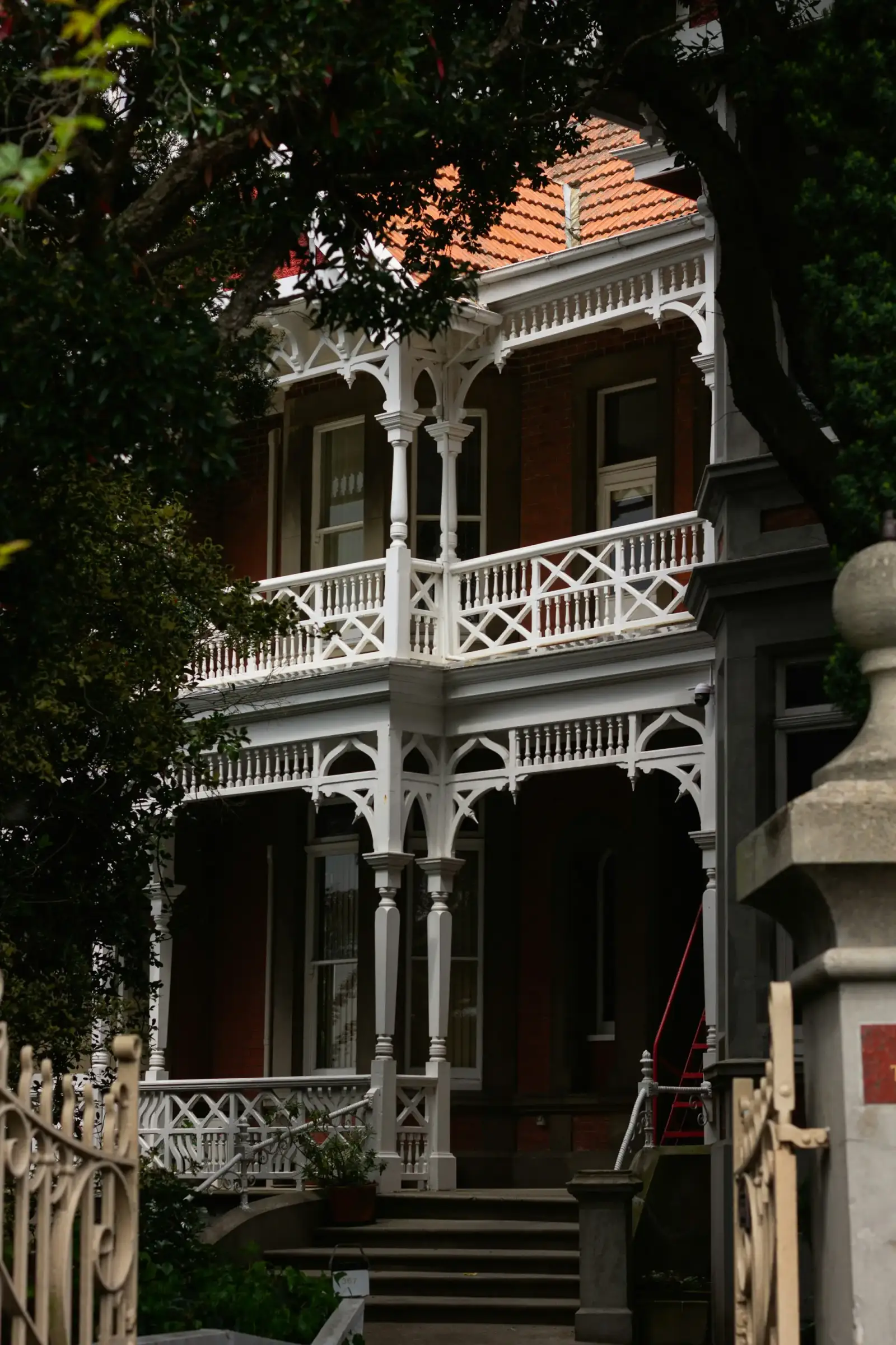 A large white house with a red roof and a wide porch